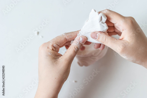 young artist hands in the process of creating a masterpiece of white polymer clay on white, art concept