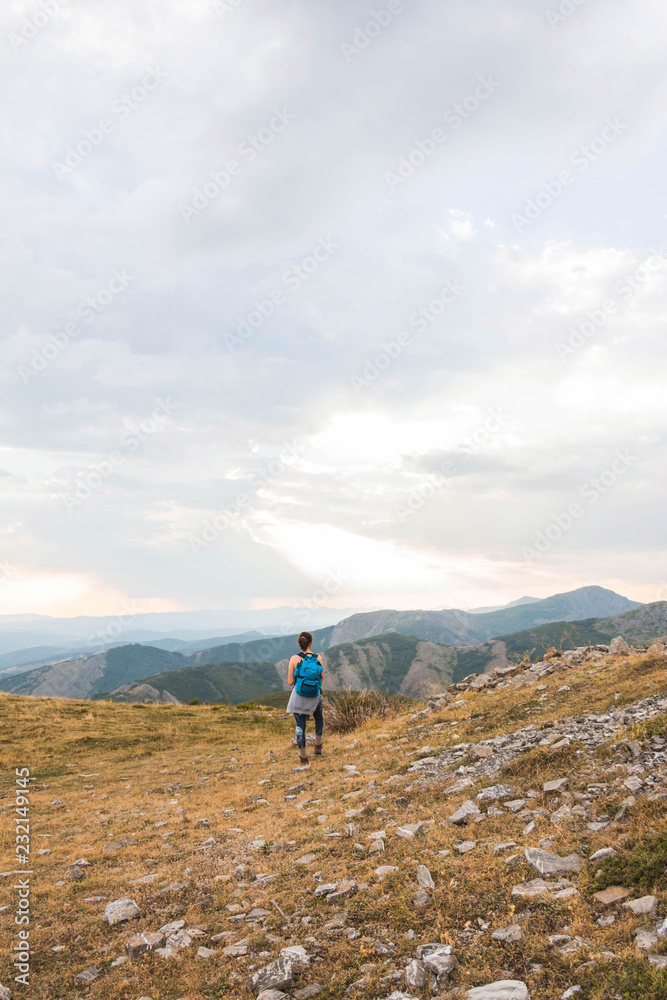 Woman with backpack against mountain range Woman with backpack against mountain range