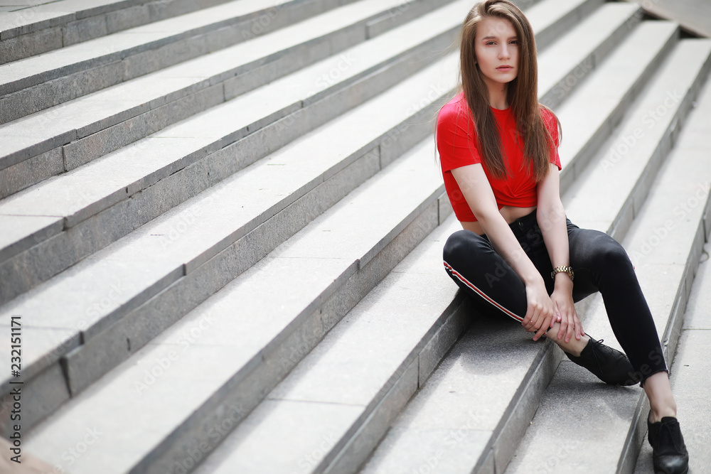 A girl posing on the steps of a building A girl posing on the steps of a building
