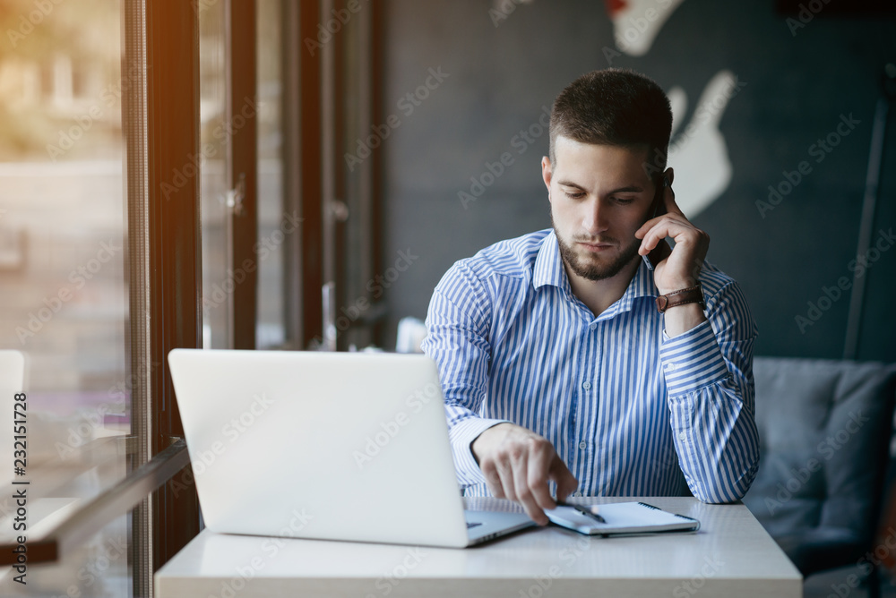 Young man drawing template for the web site associated with digital marketing, current trends and tendencies of UX / UI design. Businessman who rules his company remotely, like a freelancer Young man drawing template for the web site associated with digital marketing, current trends and tendencies of UX / UI design. Businessman who rules his company remotely, like a freelancer
