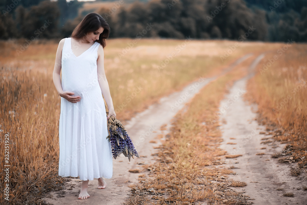 Pregnant woman in nature for a walk in the autumn