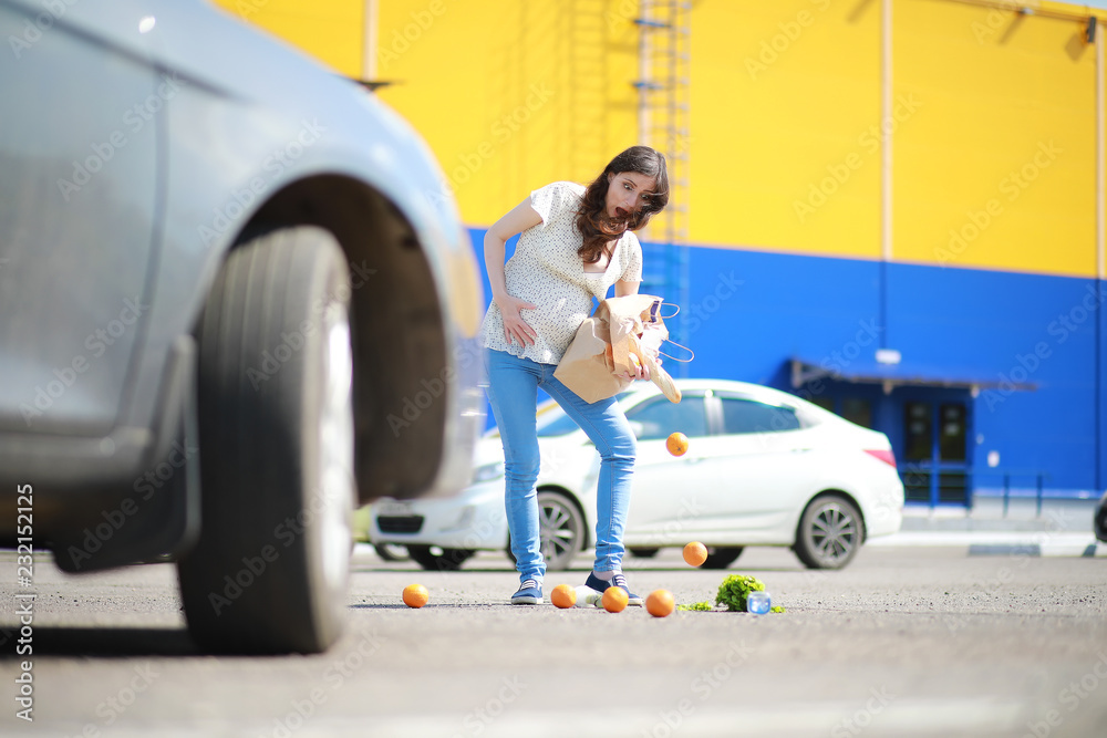 Pregnant woman with shopping comes from the store Pregnant woman with shopping comes from the store