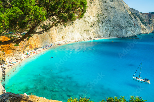 Porto Katsiki beach in Lefkada island, Greece. Beautiful view over the beach. The water is turquoise and there are tourists on the beach and a boat on the sea. © Lucian Bolca