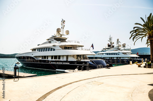 Two dazzling white luxury yachts at the pier of Bay of Kotor. Tivat, Montenegro © Julia Bazina