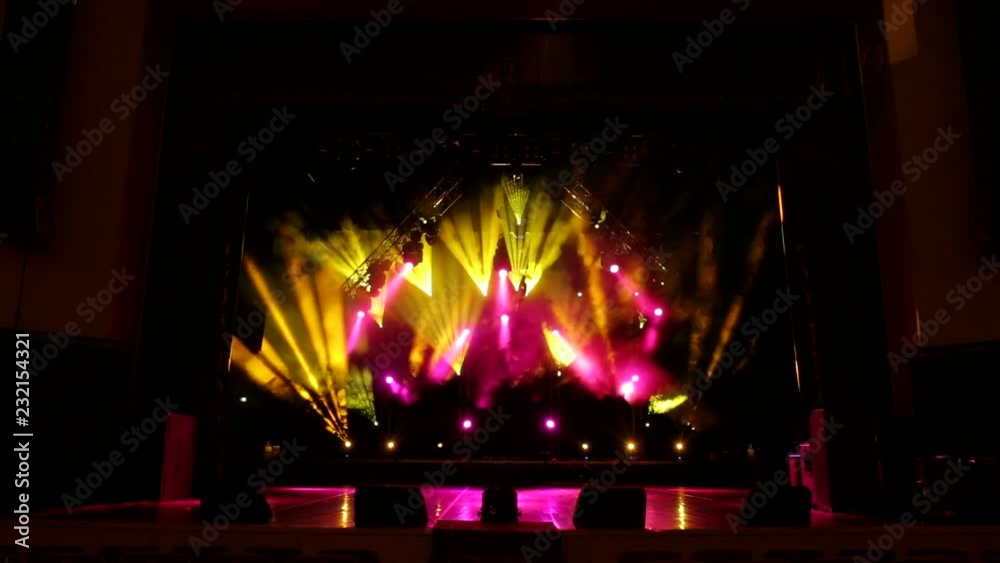 Colorful light flashing and white rays on an empty stage in the dark. Stage lighting. Light show. Colorful light flashing and white rays on an empty stage in the dark. Stage lighting. Light show.