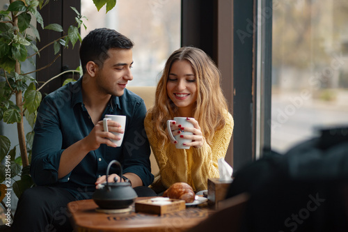 Young couple in love sitting in a cafe, drinking coffee