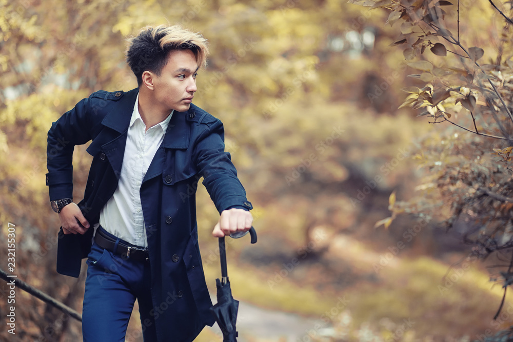 Autumn rainy weather and a young man with an umbrella