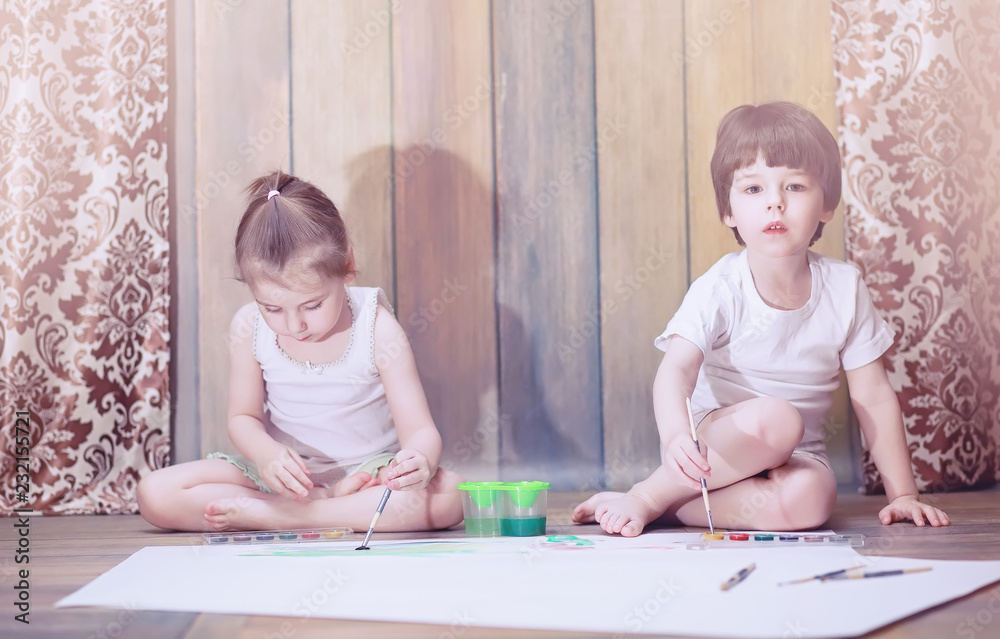 Little children paint on a large sheet of paper Little children paint on a large sheet of paper