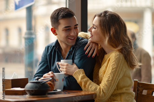 Young couple in love sitting in a cafe, drinking coffee