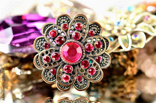 Close-up of richly decorated brooch - red artificial stones