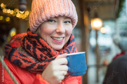 beautiful woman in scarf drinks mulled wine on christmas market © dima