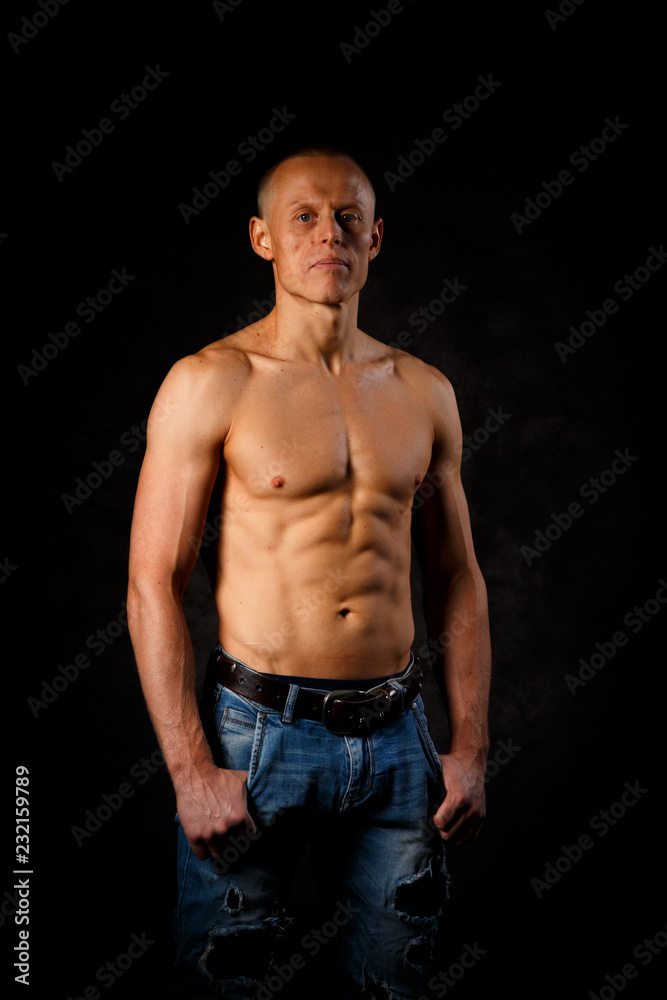 Handsome and muscular man in dark background Handsome and muscular man in dark background