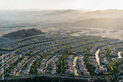 Late afternoon aerial view towards new suburban homes and streets in the sprawling Porter Ranch neighborhood of Los Angeles, California. The Santa Susana Mountains are in the background.