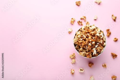 Caramel popcorn in bowl on pink background