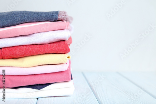 Stack of folded clothes on wooden table