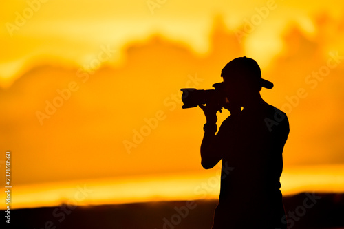 tourist with camera in the sunset