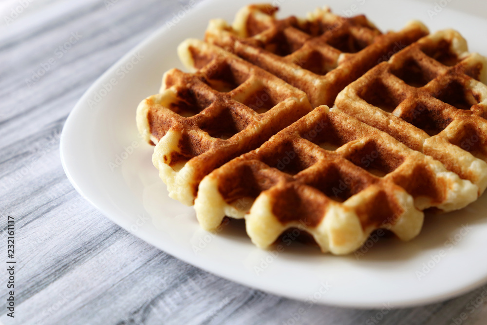 Belgian waffles on white plate. Homemade dessert Belgian waffles on white plate. Homemade dessert