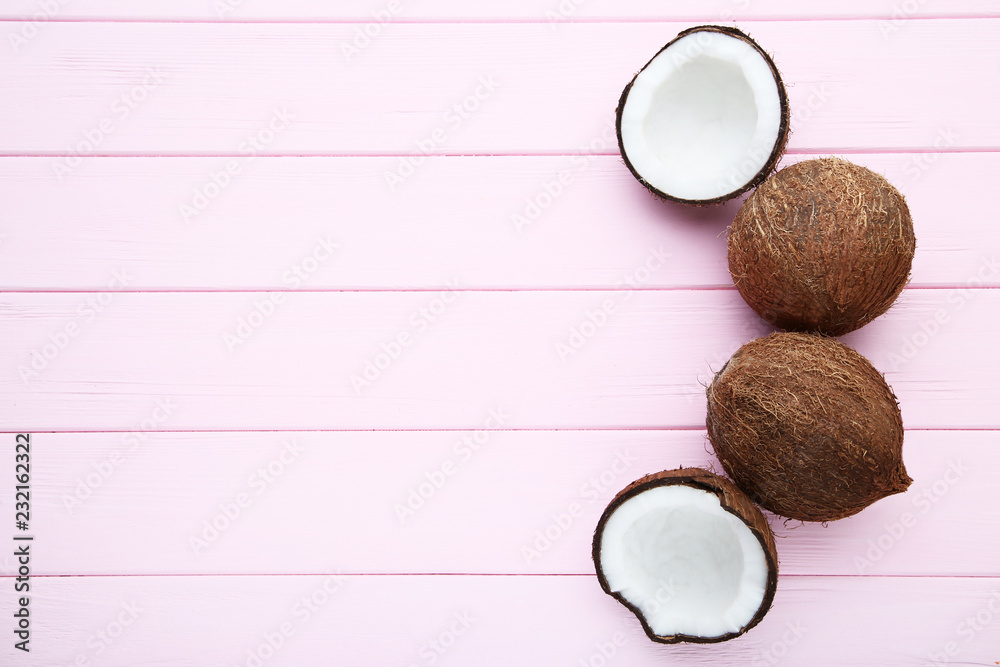 Ripe coconuts on pink wooden table Ripe coconuts on pink wooden table
