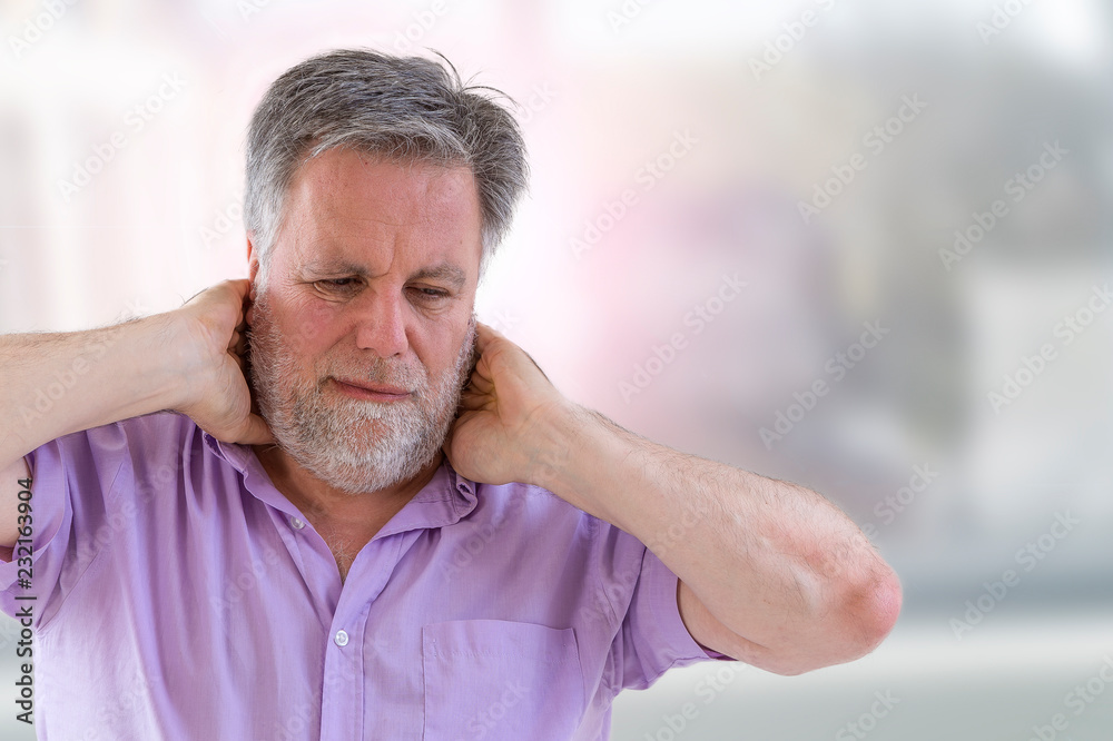 Fototapeta premium Senior man with a strong pain in the back of his neck front view
