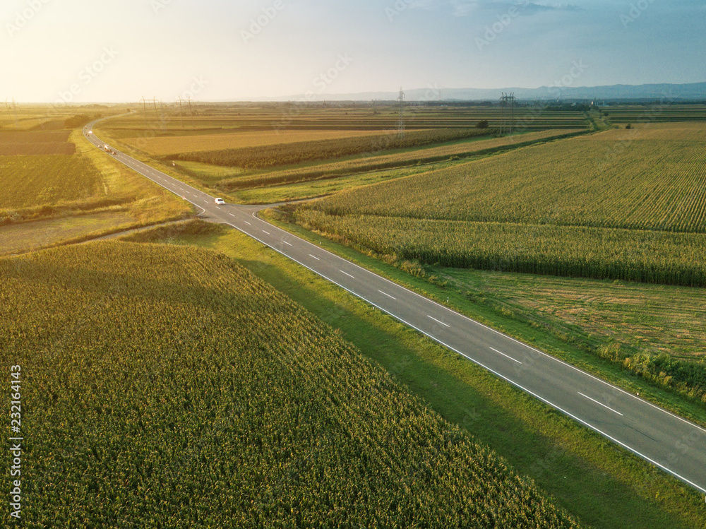 Aerial view of road through countryside and cultivated field