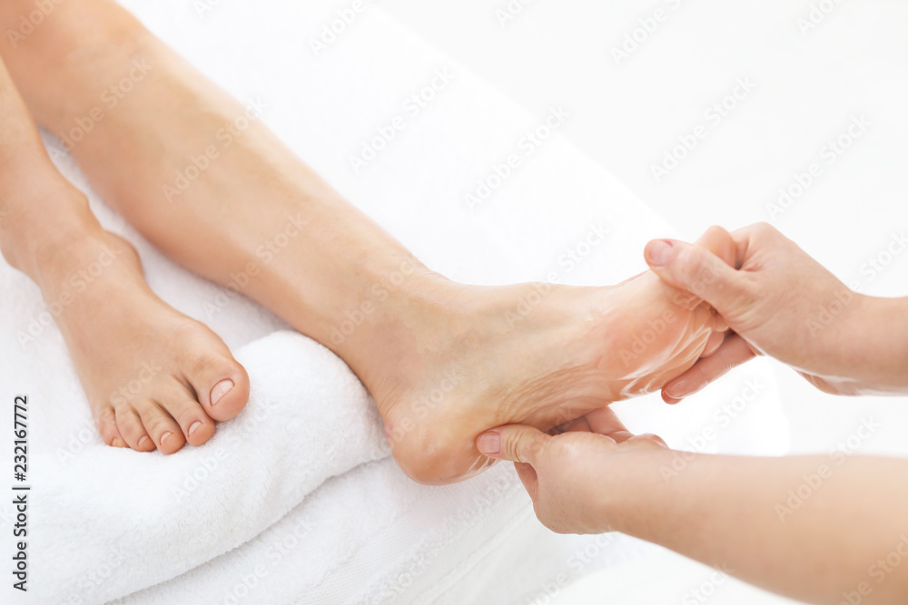 Obraz premium Woman receiving foot massage in wellness center, closeup