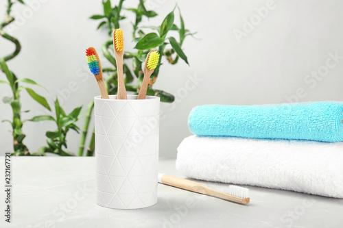 Bamboo toothbrushes and holder on table indoors. Dental care