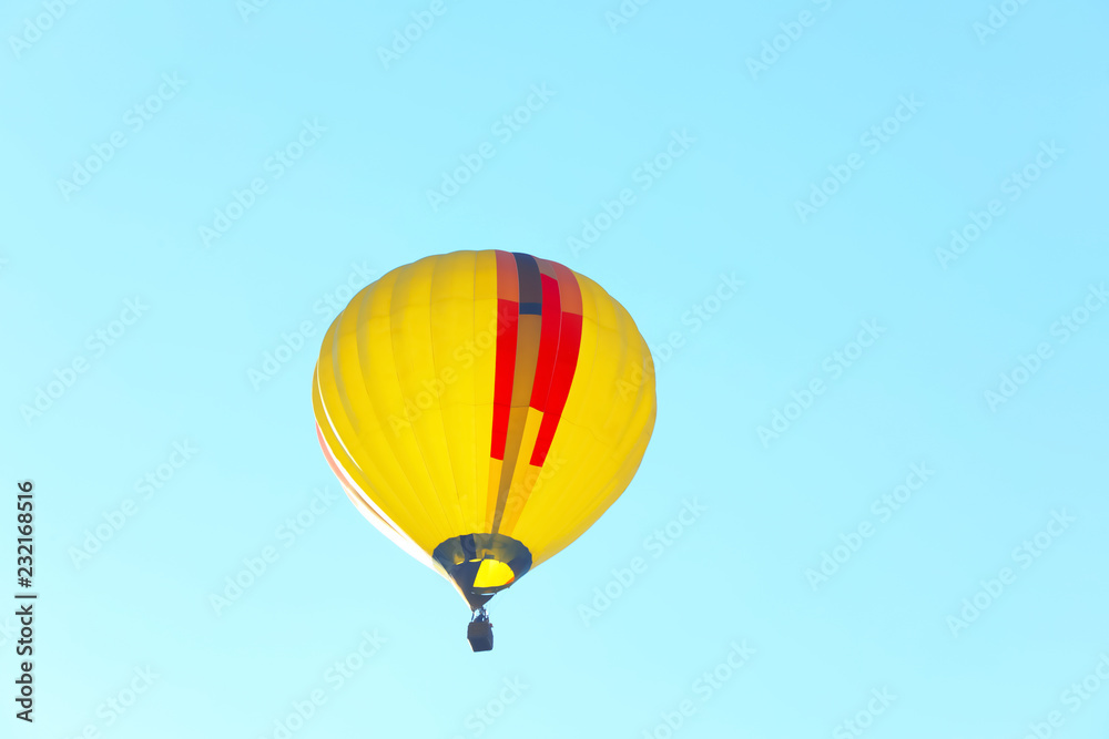 Naklejka premium Colorful hot air balloon flying in blue sky. Space for text