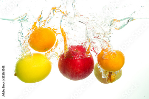 Varius fruits apple pear lemon and clementine splash in water in white