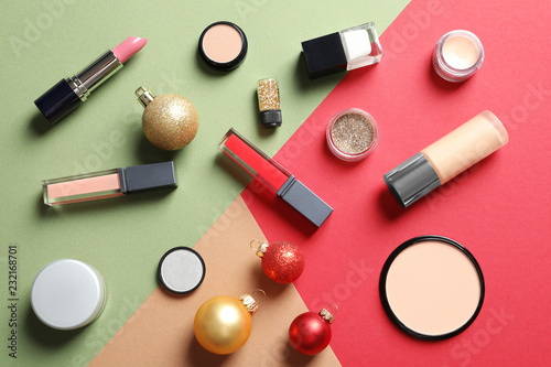 Flat lay composition with makeup products and Christmas decor on color background