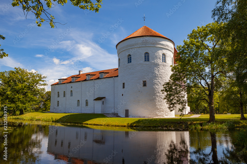 White castle Koluvere - saved medieval theasure of Estonia. Tower and wall with reflection in the pond