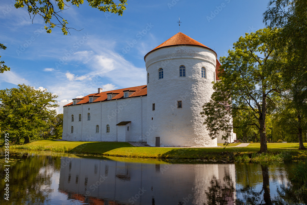 White castle Koluvere - saved medieval theasure of Estonia. Tower and wall with reflection in the pond White castle Koluvere - saved medieval theasure of Estonia. Tower and wall with reflection in the pond