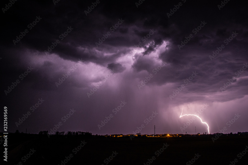 Lightning strike with purple sky over Sirvintos city in Lithuania