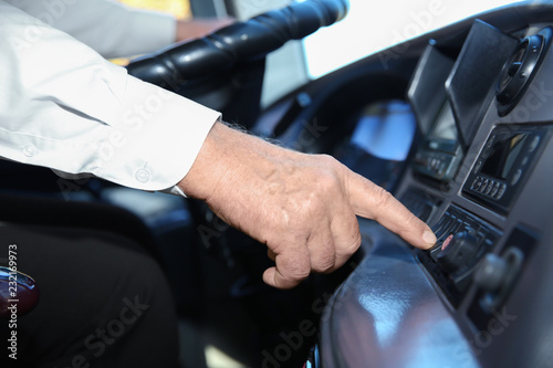 Professional bus driver pushing button on dashboard. Passenger transportation © New Africa