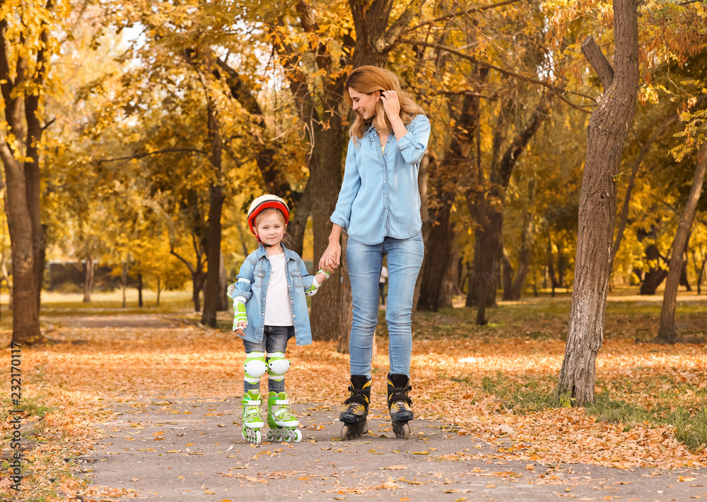 Mother and her daughter roller skating in autumn park Mother and her daughter roller skating in autumn park