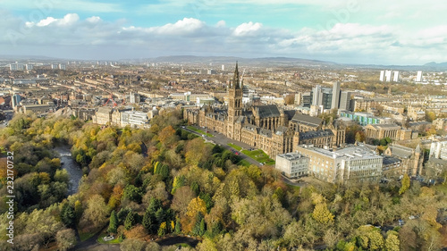 Low level aerial image over the autumn foliage of trees in Kelvingrove Park, Glasgow, to the gothic tower of Glasgow University with the cityscape behind.
