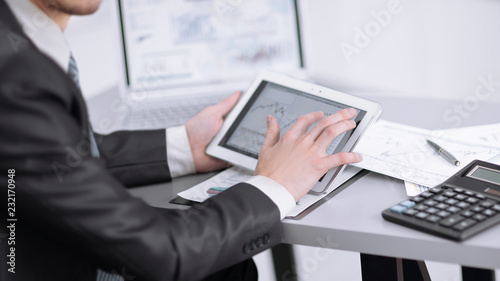 close up.the businessman uses a digital tablet to work with financial data