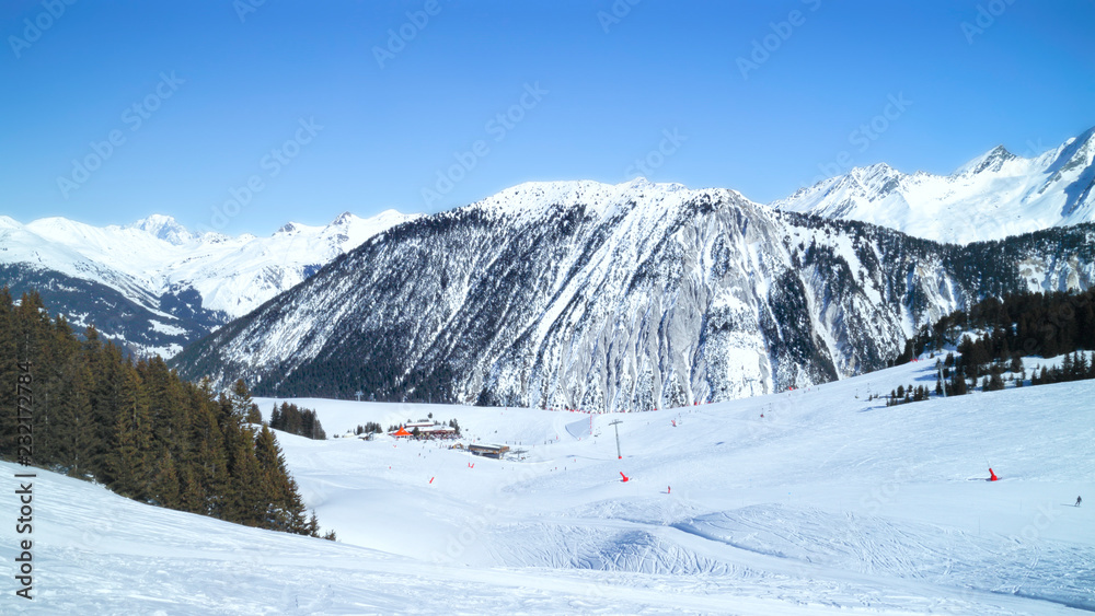 Panoramic winter landscape of skiing, snowboarding slopes pine forest, chalet restaurant, chair lift in 3 Valleys resort of Courchevel, Alps, France .