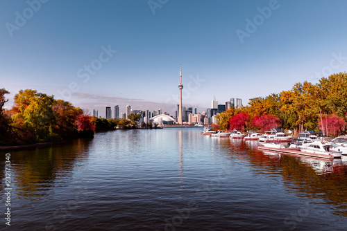 View of Toronto skyline from lake with seasonal autumn trees