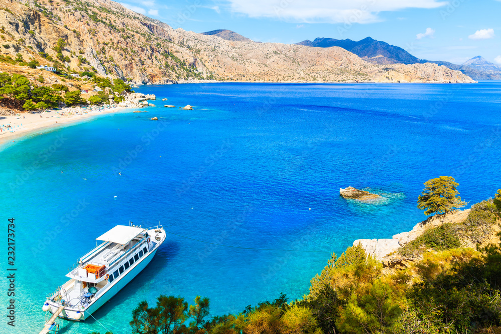 Tourist boat anchoring at beautiful Apella bay on Karpathos island, Greece