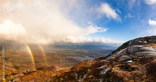 Panoramic View of blue sky and double rainbow from mountain at Grands Jardins Park in Quebec, Canada © Marius