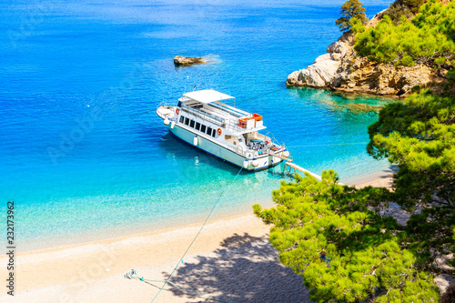 Tourist boat anchoring at beautiful Apella beach on Karpathos island, Greece