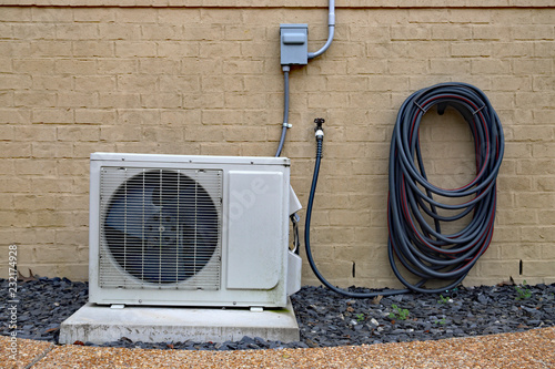 Obraz na płótnie Air Conditioner mini split system next to home with brick wall