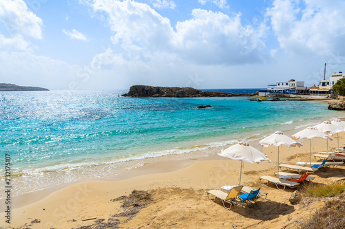 Sunbeds on beautiful beach in Lefkos village on coast of Karpathos island, Greece.