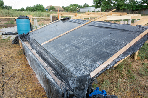 A box-platform for the impregnation of pine boards with an antiseptic protective agent against insects and fire. Construction of the frame house. photo