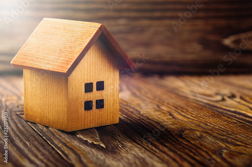 Real estate concept with small toy wooden house on wooden background. Idea for real estate concept, personal property and family house.