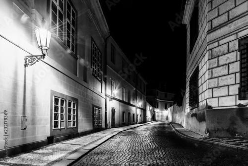 Valokuva Narrow cobbled street in old medieval town with illuminated houses by vintage street lamps, Novy svet, Prague, Czech Republic