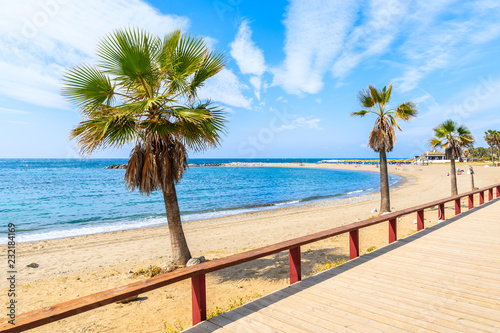 Coastal walkway and palm trees on beach in Marbella town, Spain