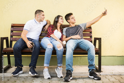 Three teenagers taking selfies