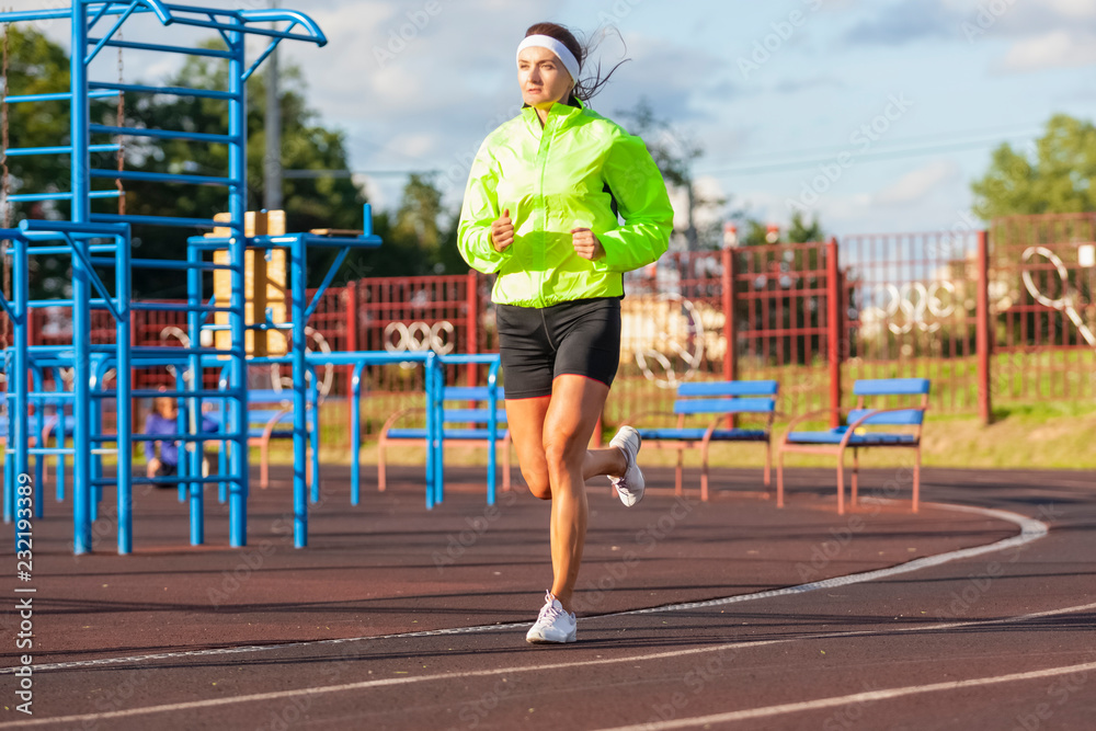 Jogging Concepts. Portrait of Professional Female Runner During Training.  Running on Track and Equipped in Summer Training Outfit While Running. Stock  Photo