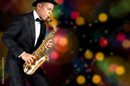 Close-up man playing on saxophone on background